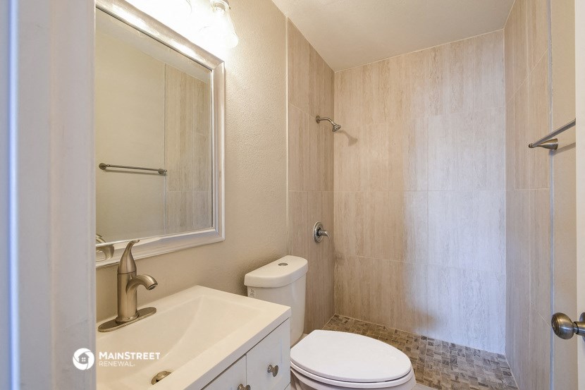 a bathroom with a sink toilet and a mirror
