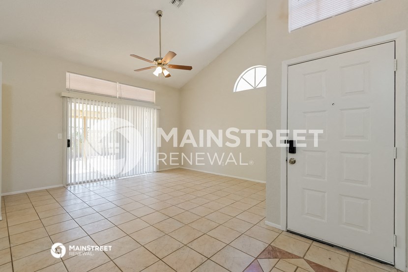 a large living room with a white door and a tile floor