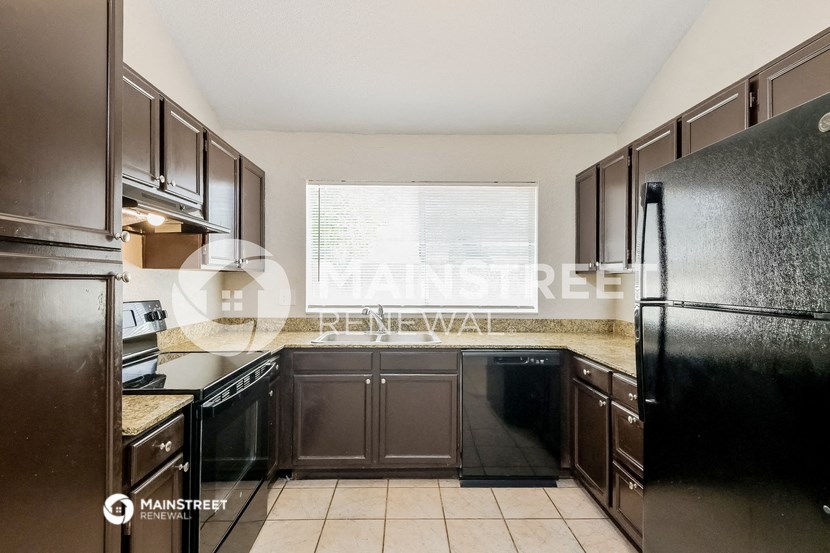 a kitchen with black appliances and brown cabinets