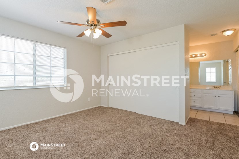 a master bedroom with a large closet and a ceiling fan