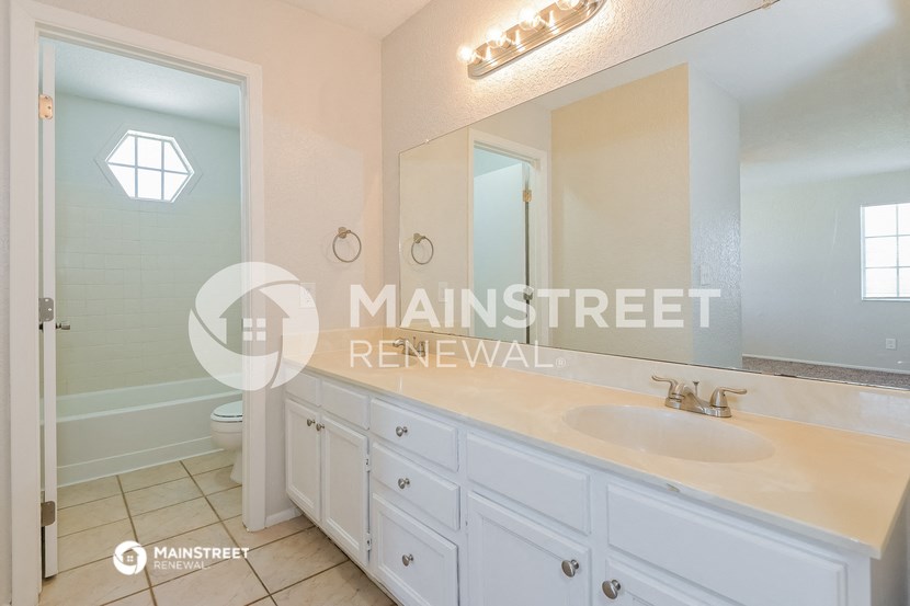 a white bathroom with a sink and a mirror