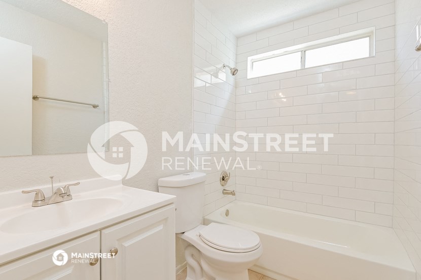 a white bathroom with a tub and a sink and a toilet