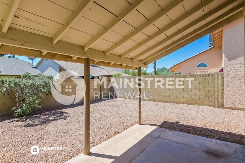 a view of the entrance to a driveway under a covered patio