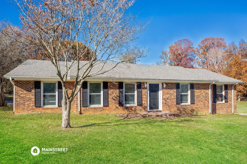 a brick house with a tree in the front