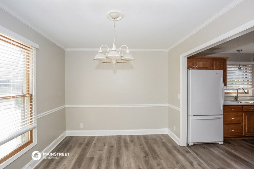 an empty kitchen with a refrigerator and a window