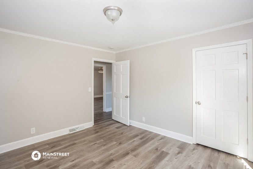 the living room of a renovated house with white walls and wood floors