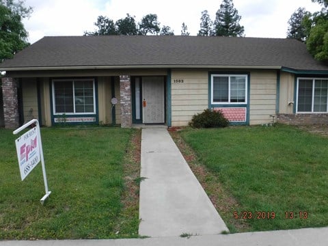 front view of a house with afor sale sign on the sidewalk