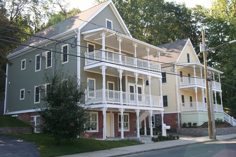 a large house with a balcony on a street