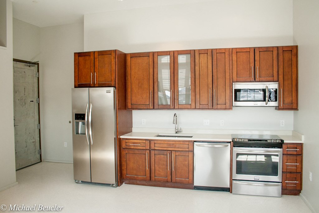 a kitchen with wooden cabinets and stainless steel appliances