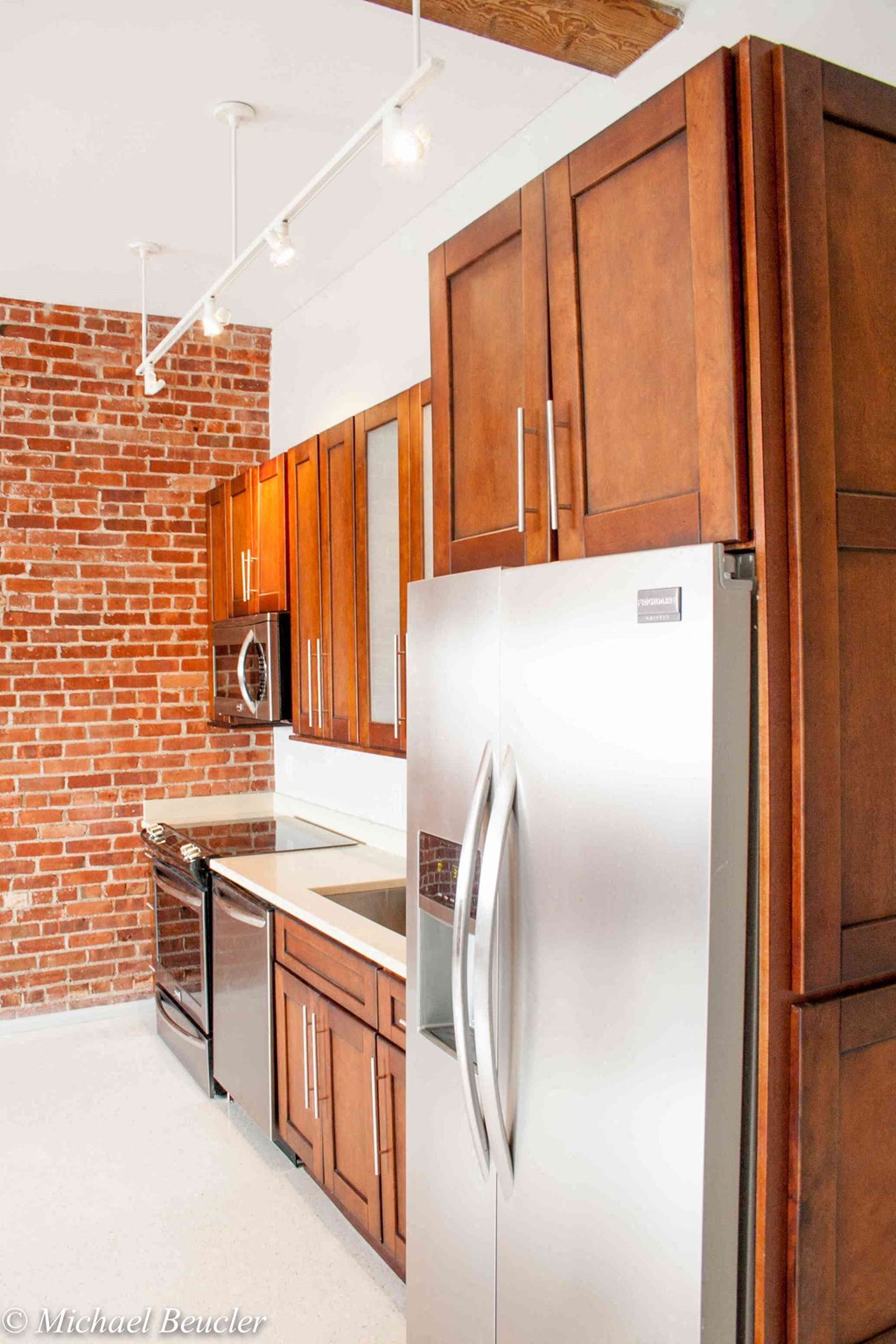 a kitchen with a stainless steel refrigerator and wooden cabinets