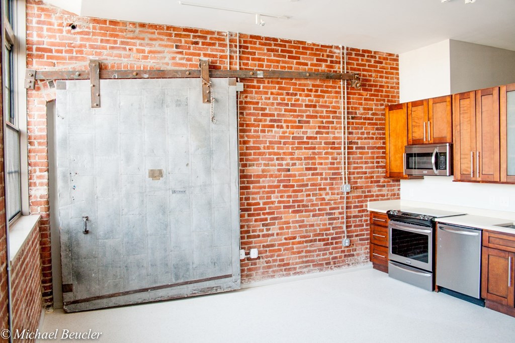 a kitchen with a brick wall with a sliding door
