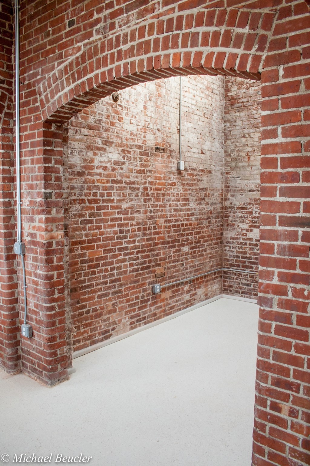 a room with a brick archway and a white floor