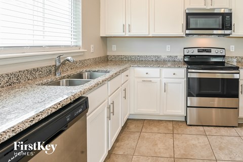 a kitchen with granite counter tops and white cabinets