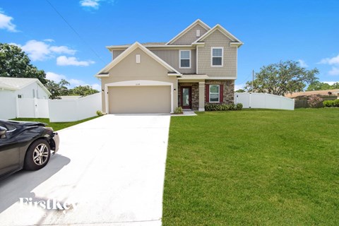 a home with a lawn and a car parked on the driveway
