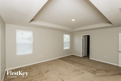 the master bedroom has a vaulted ceiling and travertine floors