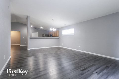 A spacious room with wooden flooring and a white ceiling.