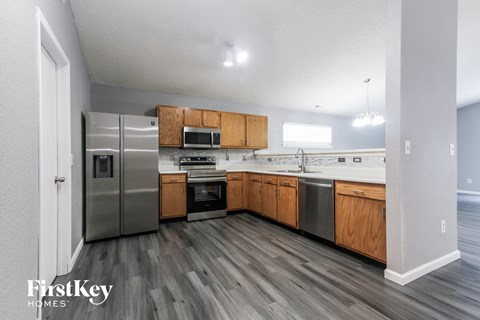 A kitchen with wooden cabinets and a stainless steel refrigerator.
