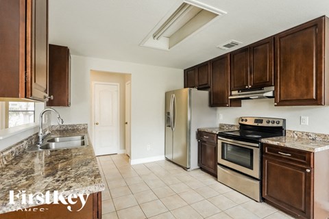 A kitchen with a stove top oven and a refrigerator.