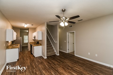 an open kitchen and living room with a ceiling fan