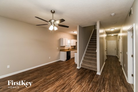 a living room with a staircase and a ceiling fan