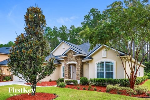 A house with a red mulch bed in front of it.
