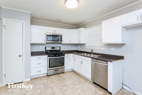 A kitchen with white cabinets and a stainless steel dishwasher.