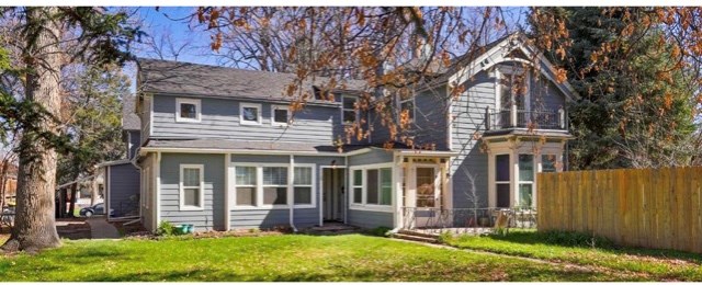 a blue house with a yard and a wooden fence