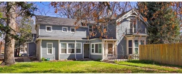 a blue house with a yard and a wooden fence
