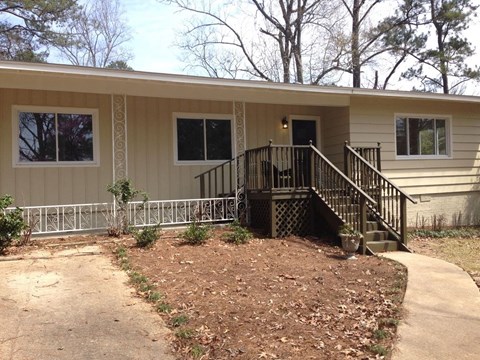 A small house with a brown front yard.