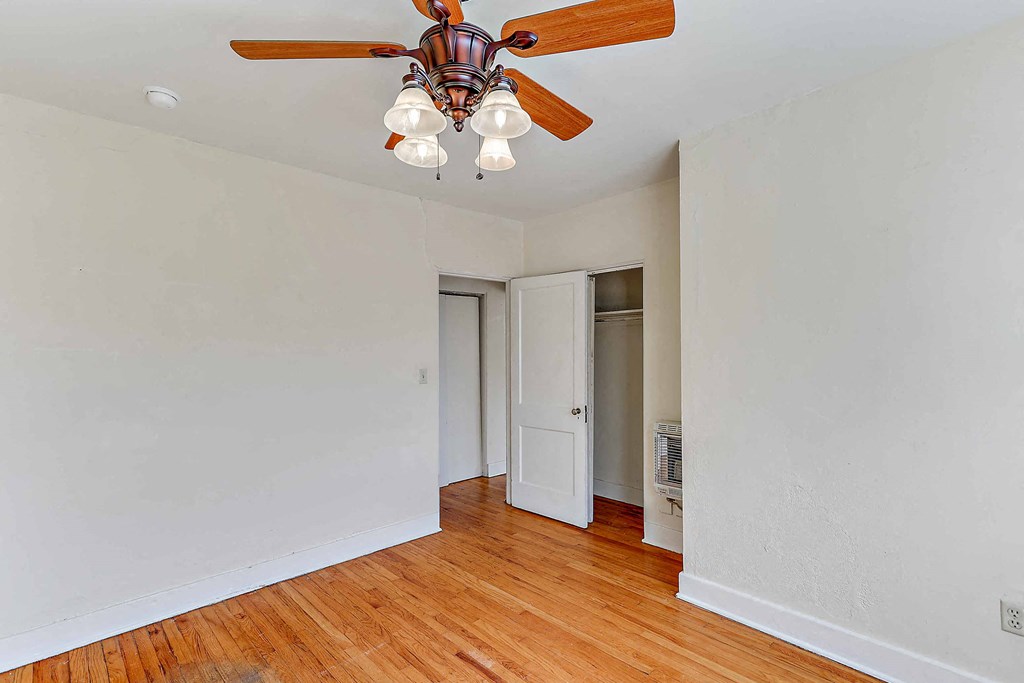 a living room with a ceiling fan and a door to a closet