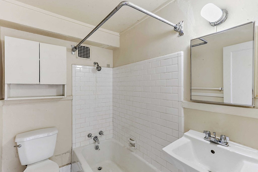 a bathroom with a toilet sink and tub and a mirror