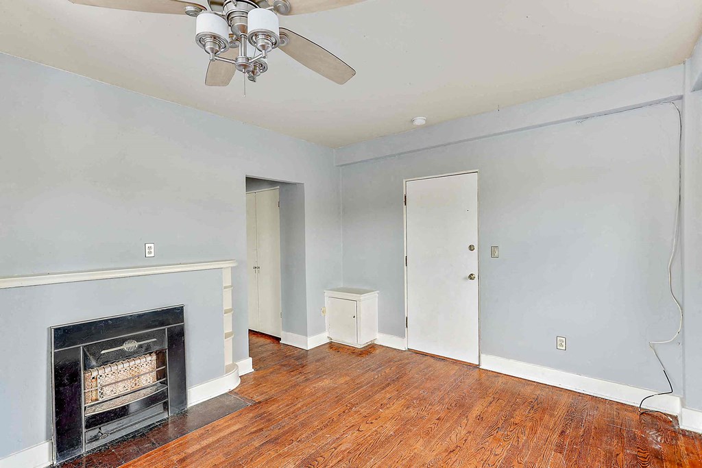a living room with a fireplace and a ceiling fan