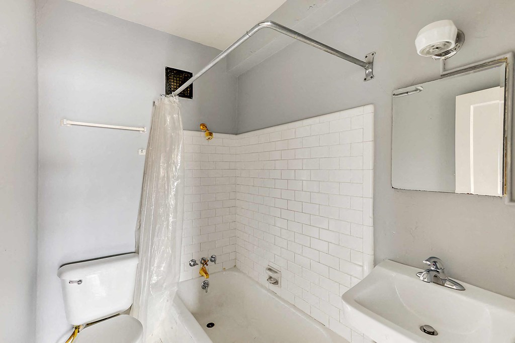 a white bathroom with a shower and a sink