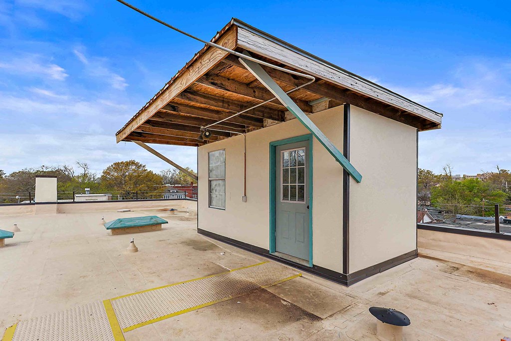 a small building with a blue door on a roof