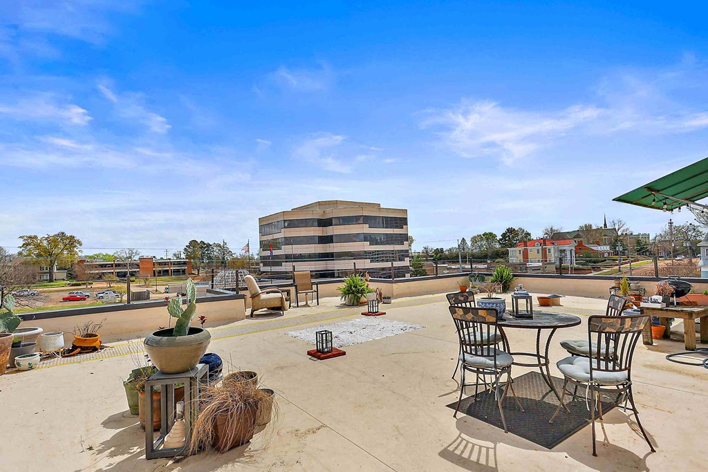 the patio on the roof of the building has tables and chairs