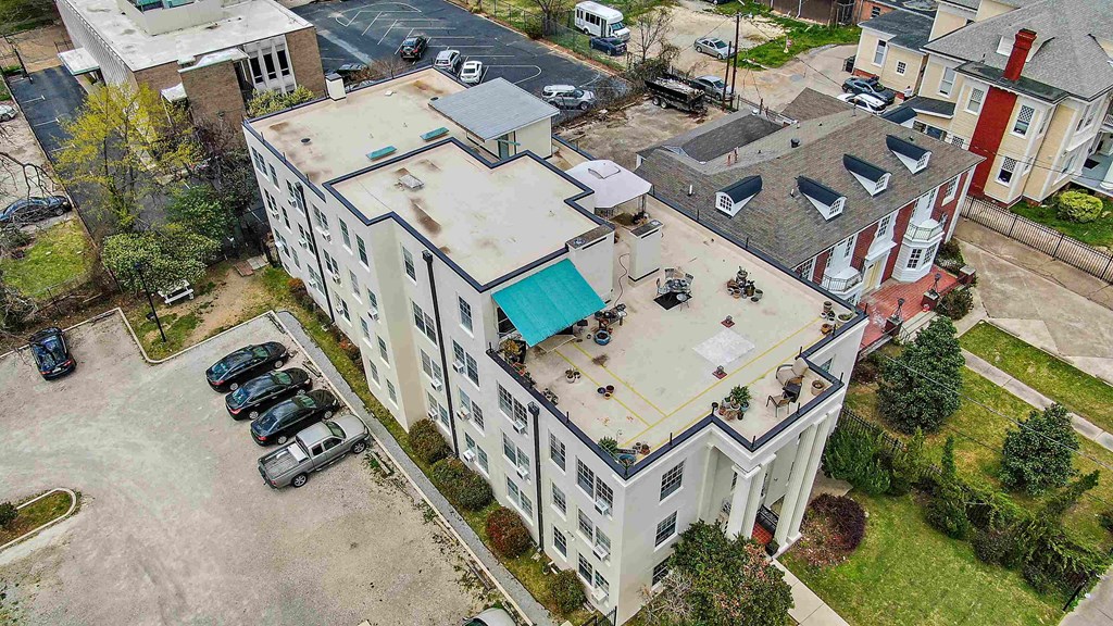 an aerial view of a building with a blue roof and a parking lot
