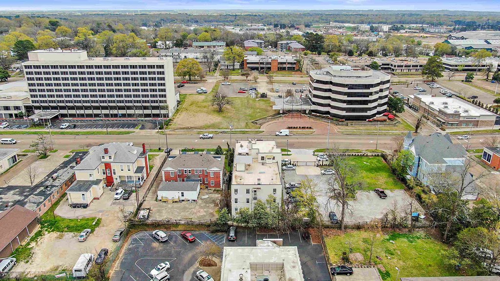 an aerial view of a city with a parking lot and buildings