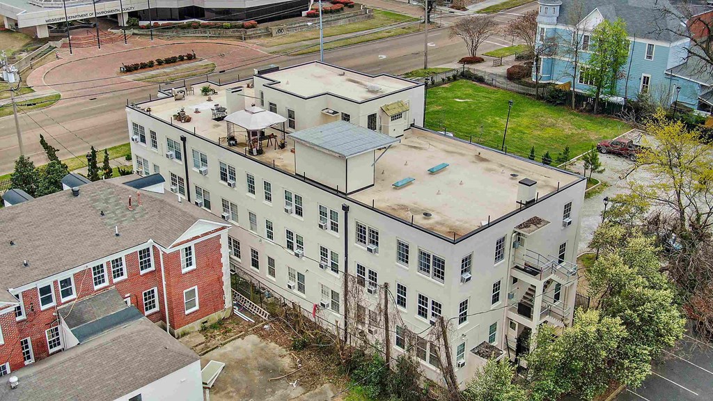 an aerial view of a white building with a rooftop court