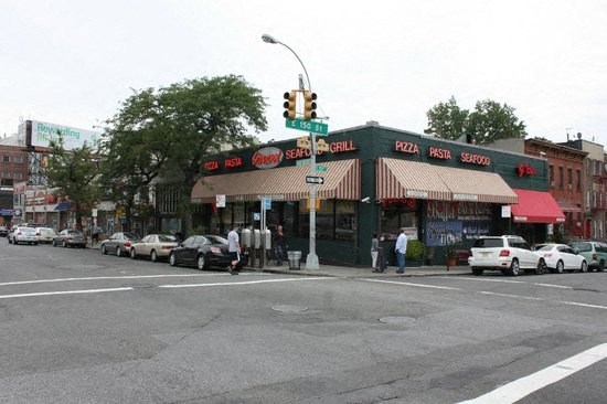 a busy intersection with cars parked in front of a store
