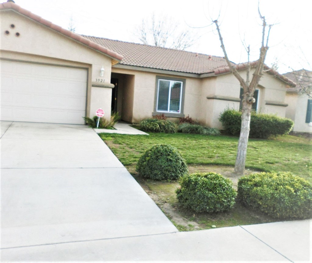 a house with a yard and a sidewalk in front of it