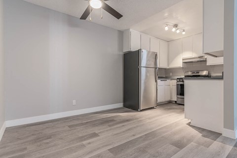 a kitchen with white cabinets and a stainless steel refrigerator