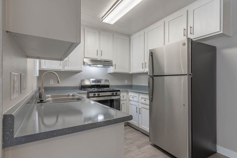 a kitchen with white cabinets and stainless steel appliances