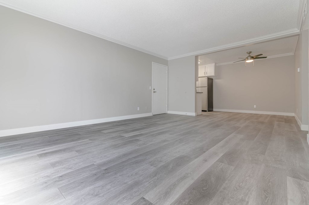 an empty living room with white walls and wood floors