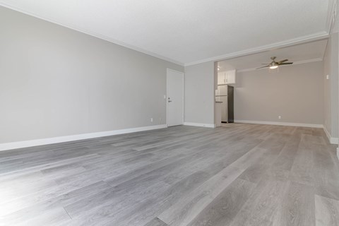 an empty living room with white walls and wood floors