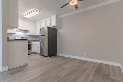 a kitchen with white cabinets and a stainless steel refrigerator
