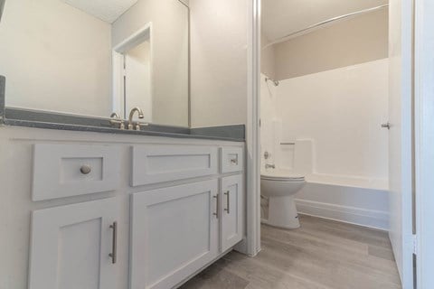a white bathroom with a toilet and a sink