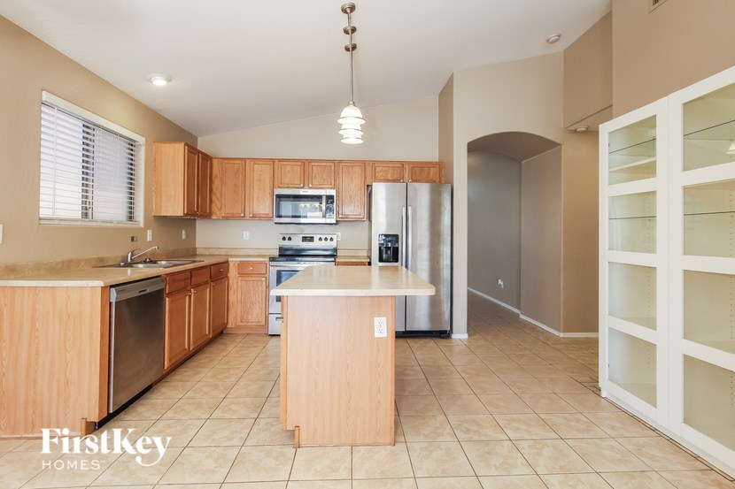 A kitchen with wooden cabinets and a tile floor.