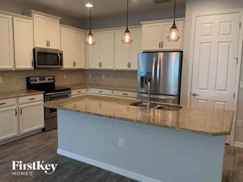 A kitchen with a granite countertop and stainless steel appliances.