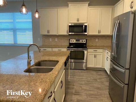 A kitchen with a granite countertop and stainless steel appliances.