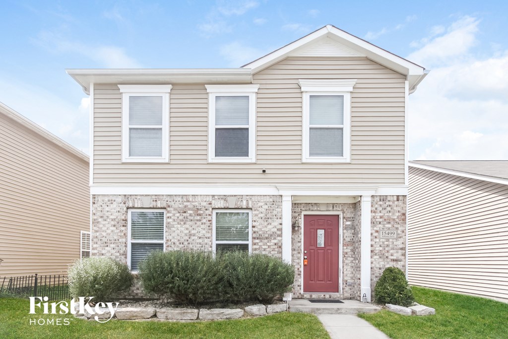 A house with a red door and a sign that says "FirstKey Homes".